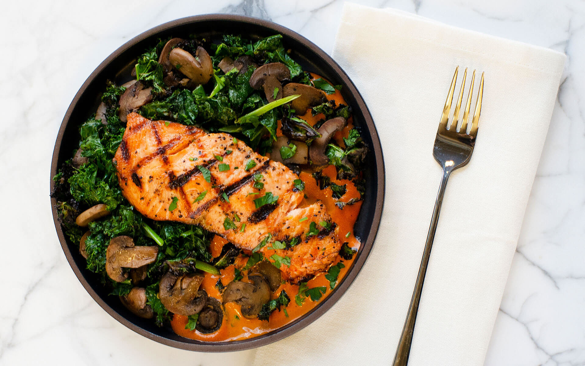 salmon, mushrooms and greens on a plate