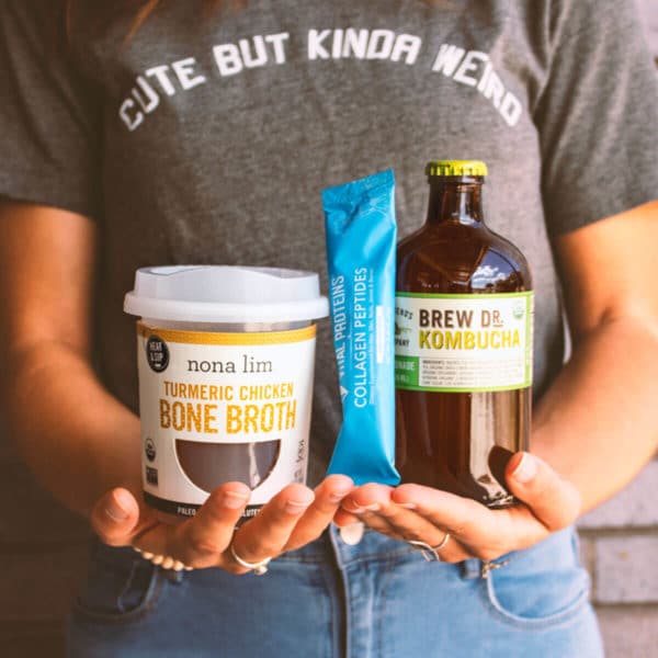 person holding containers with bone broth, collagen peptides and kombucha