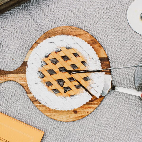 closeup of someone cutting into a blueberry pie