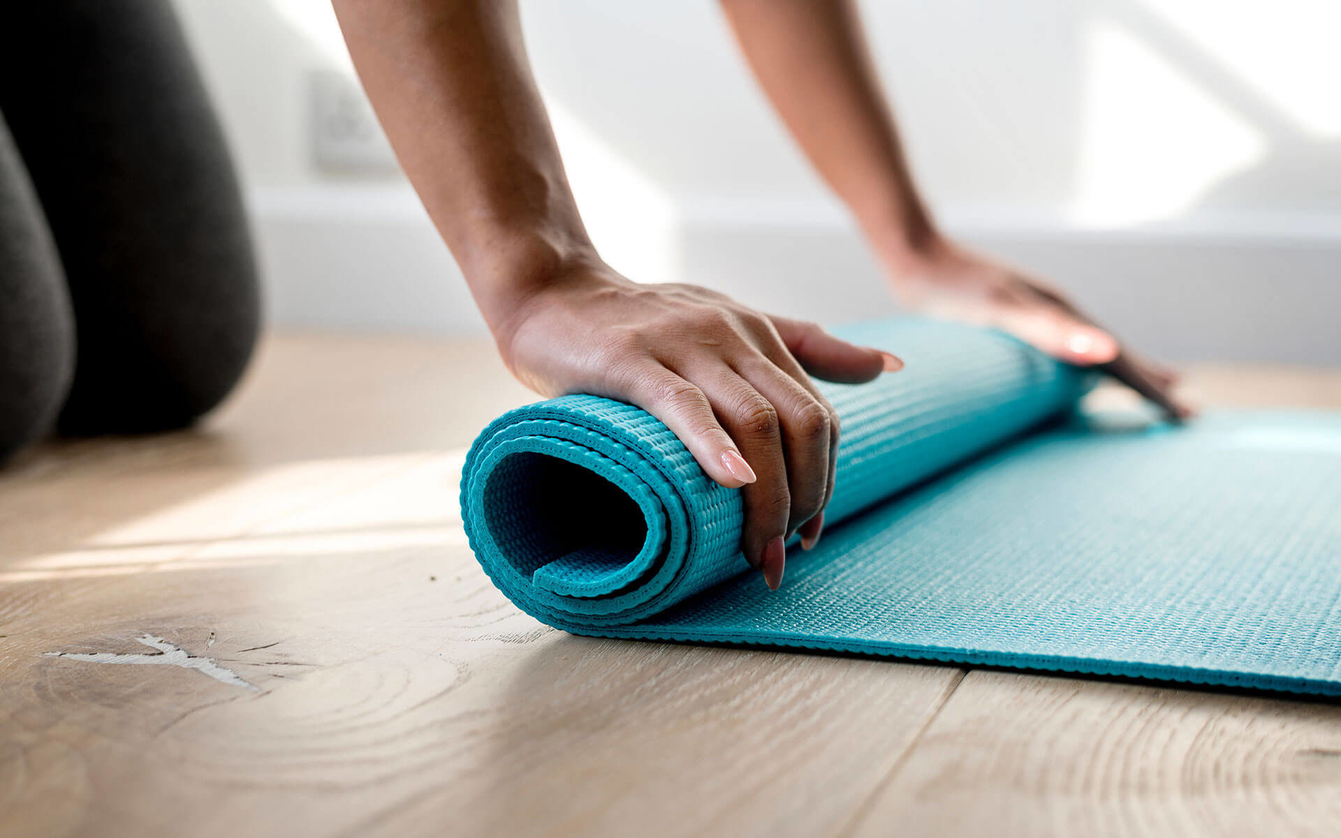 close up of someone rolling up a yoga mat