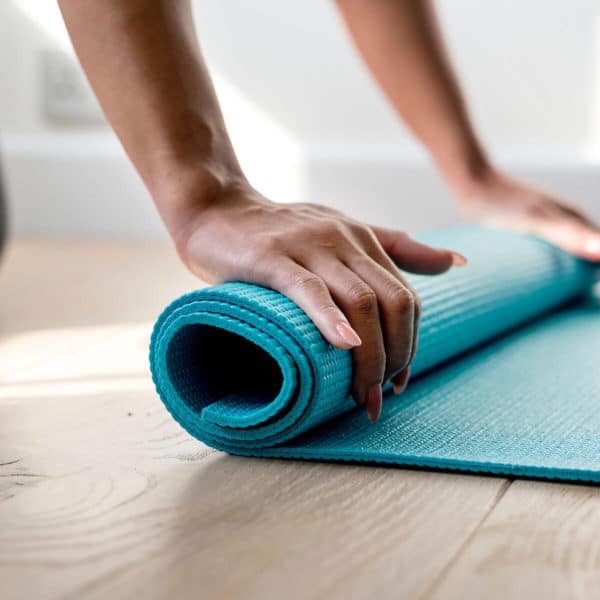 close up of someone rolling up a yoga mat