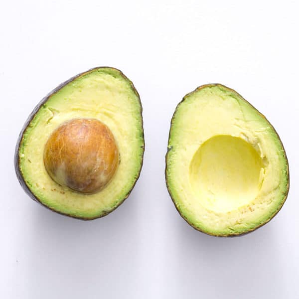 avocado sliced in half on a white background