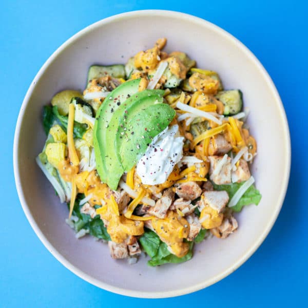 taco bowl with chicken, veggies, avocado and cheese