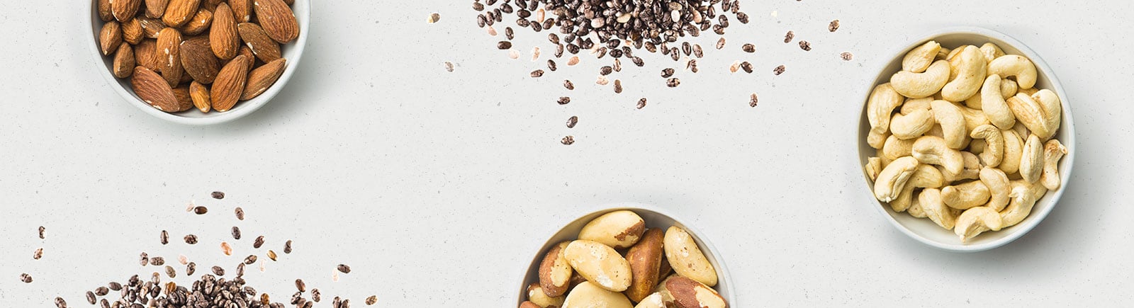 header image of nuts and seeds in bowls and scattered on the ground