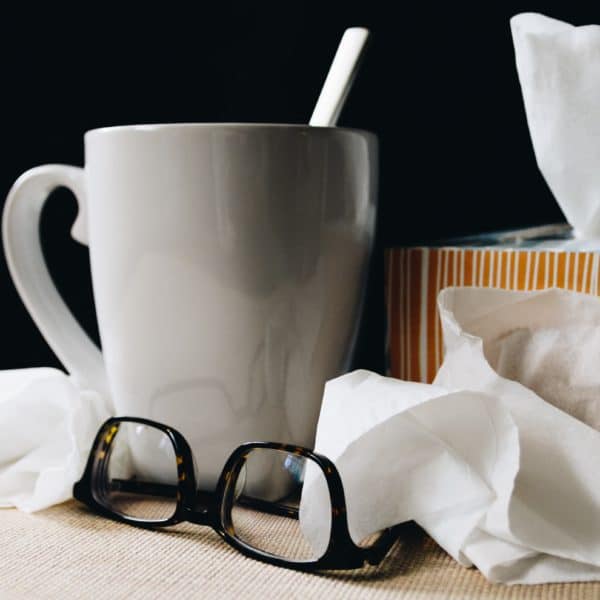 photo of tissues, tea in a mug and glasses