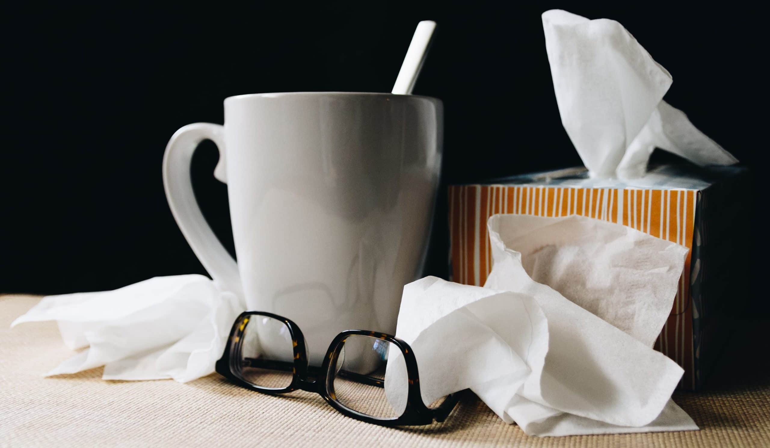 photo of tissues, tea in a mug and glasses