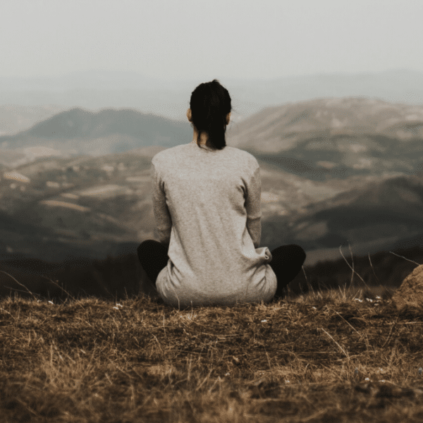 woman meditating in front of mountain landscape