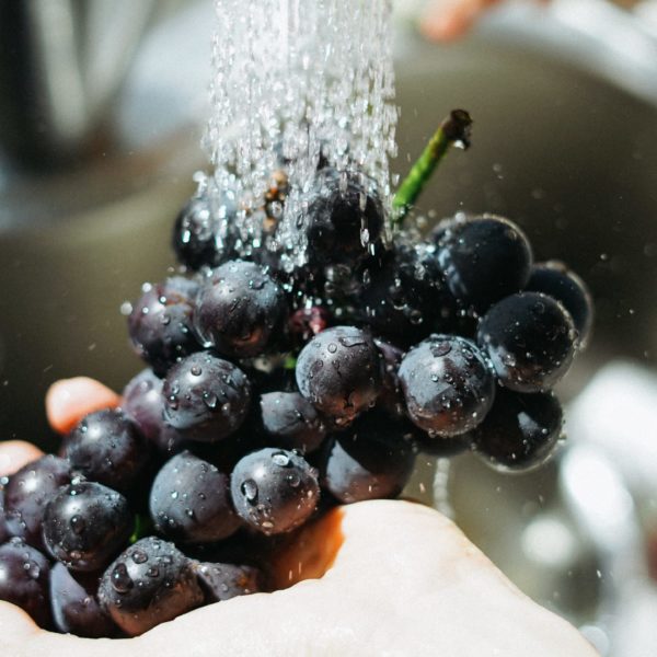 grapes being washed to avoid toxin exposure