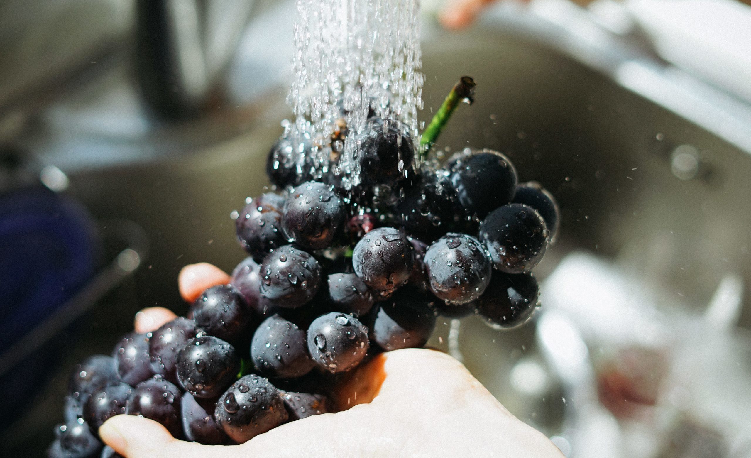 grapes being washed to avoid toxin exposure