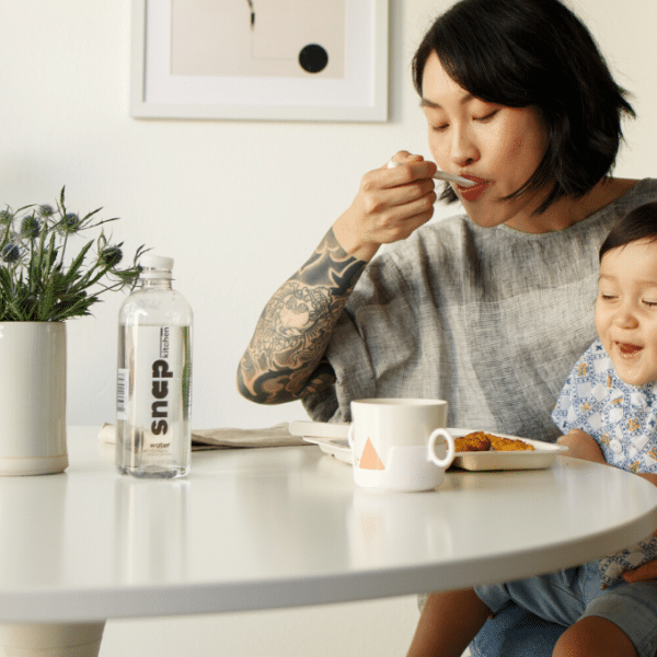 Mom and young child eating at kitchen table