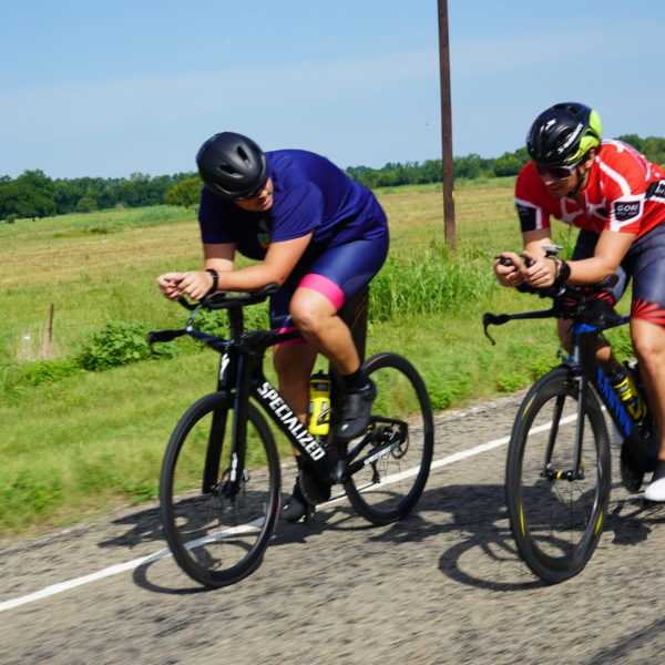 Two people on bikes on a paved road