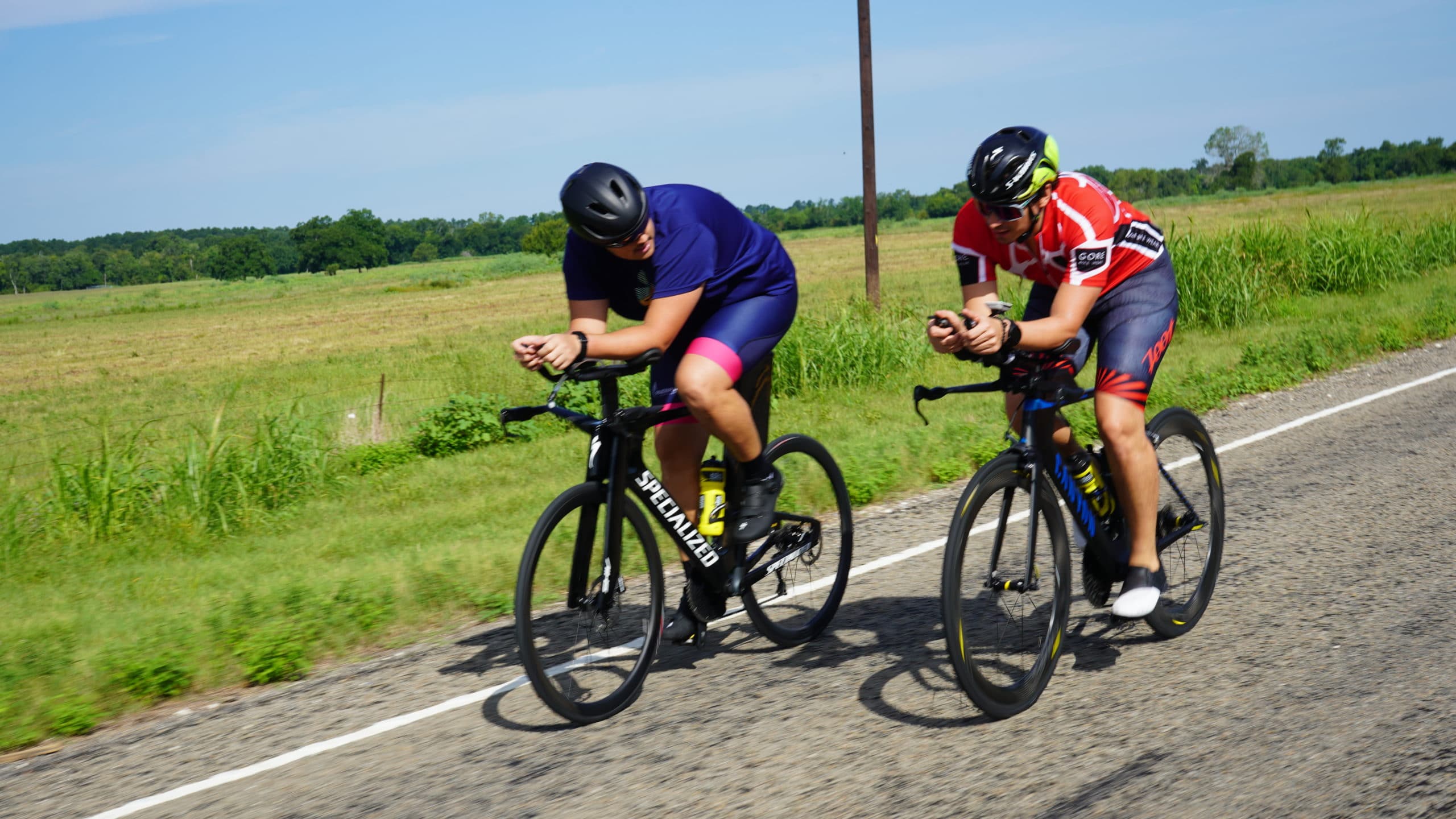 Two people on bikes on a paved road