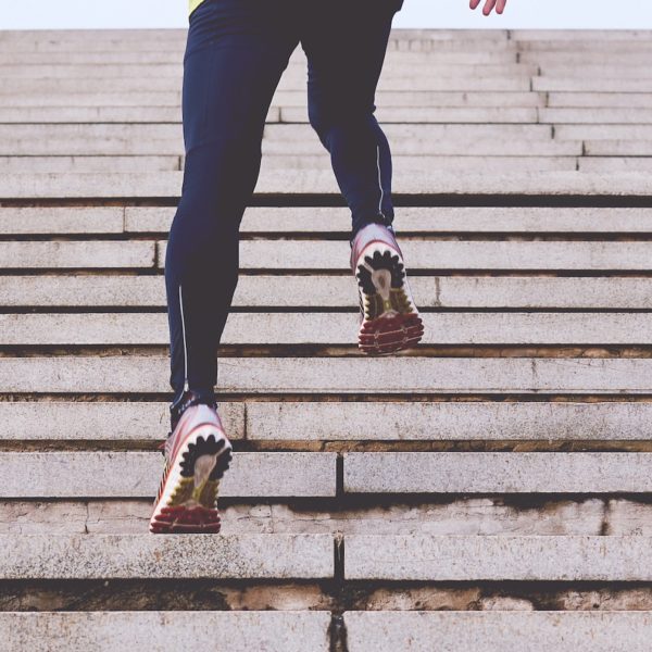 Person in leggings running up steps