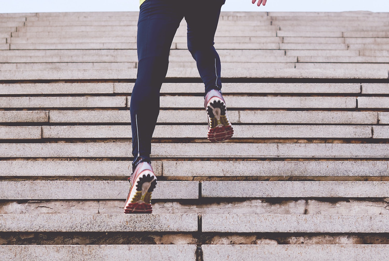 Person in leggings running up steps