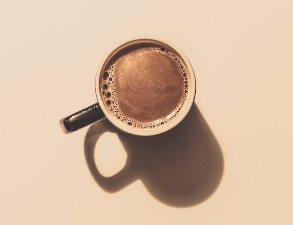 Mug of coffee on a tan background