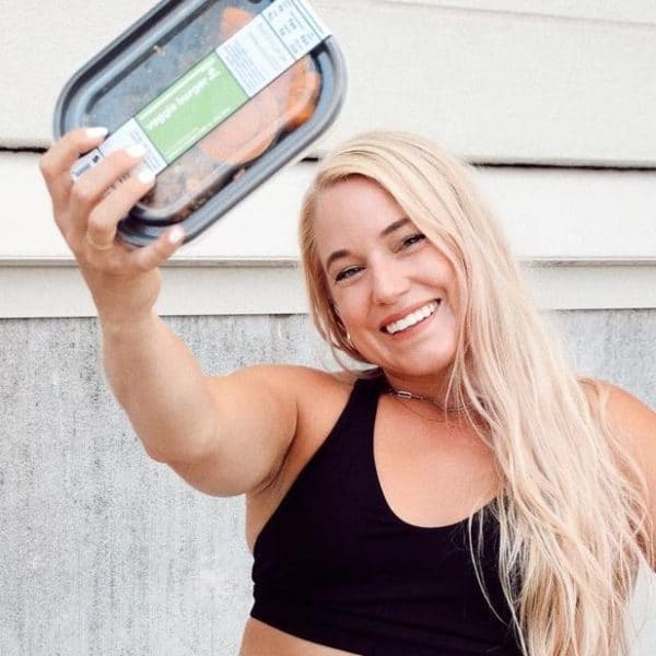 Smiling woman holding a packaged meal