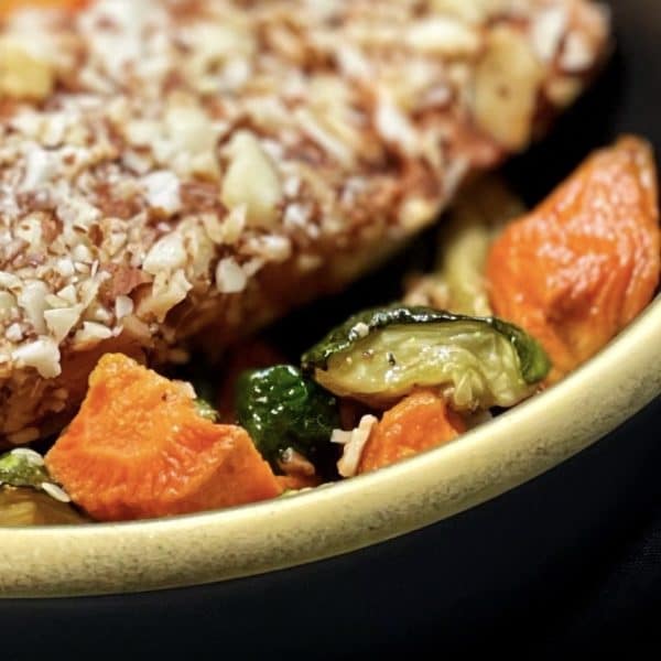 Closeup of almond crusted salmon with zucchini and carrots