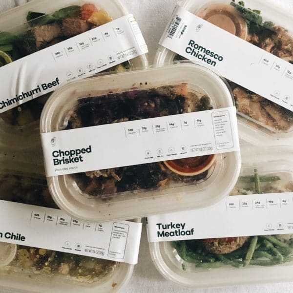 5 Snap Kitchen meals on a white background - chimichurri beef, romesco chicken, chopped brisket, pork green chile and turkey meatloaf