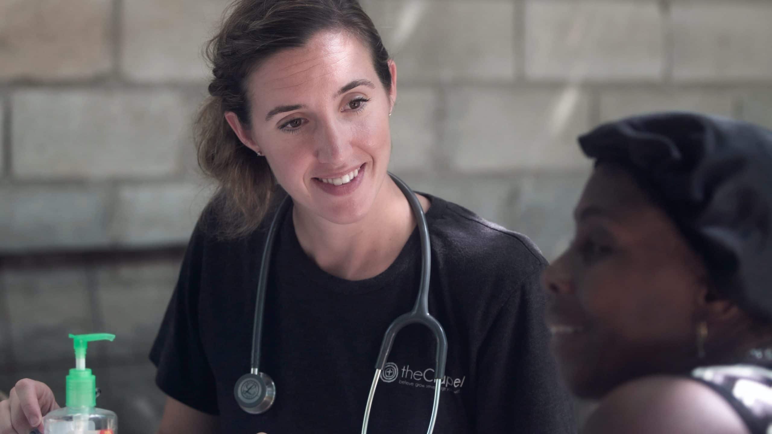 Female doctor with dark hair and a stethoscope around her neck