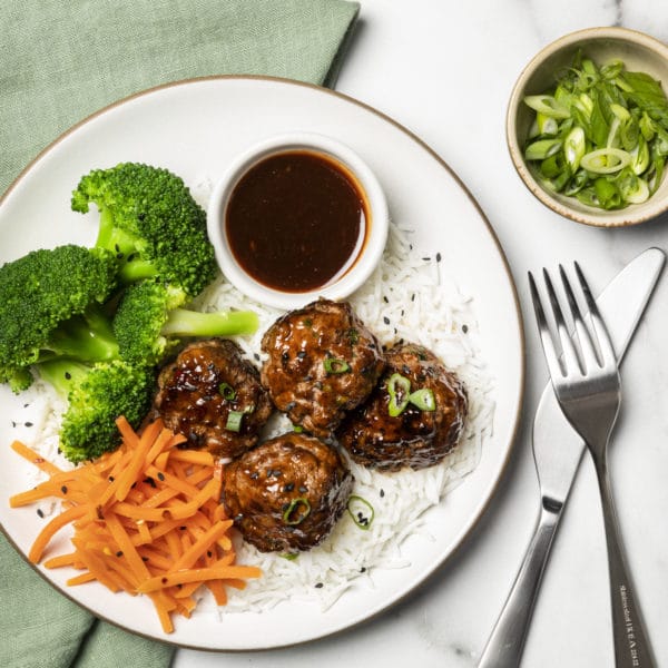 A plate of Korean meatballs with broccoli and carrots