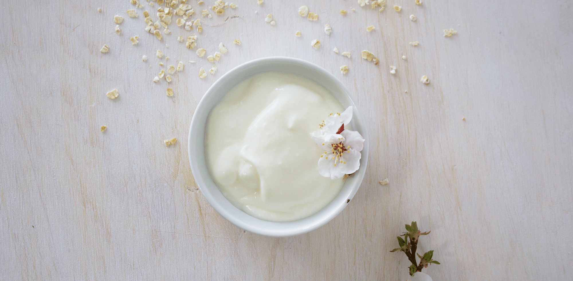 Small bowl of aioli with flower garnish on a white marble countertop