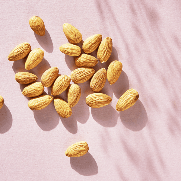 Close up of almonds on a pink background