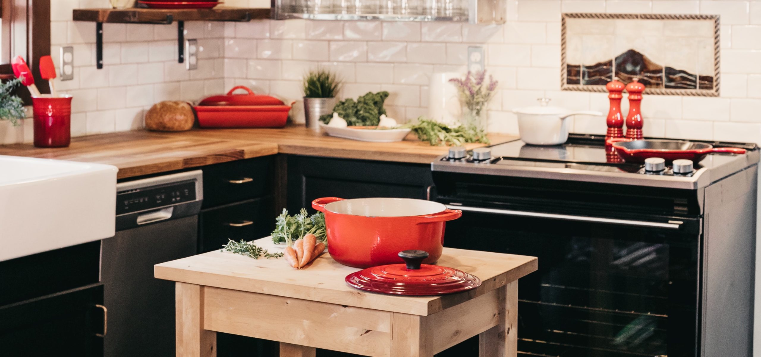 Modern kitchen with wooden island and red ceramic dutch oven