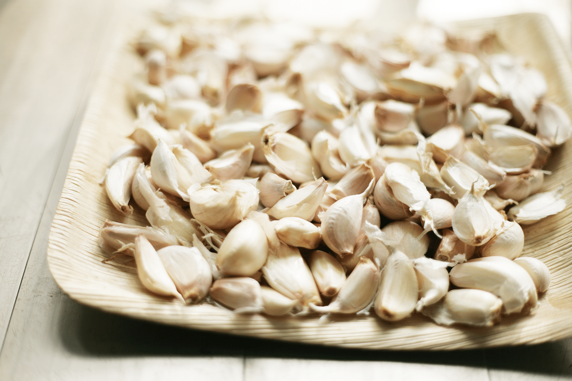 Close up of raw garlic cloves on a tray