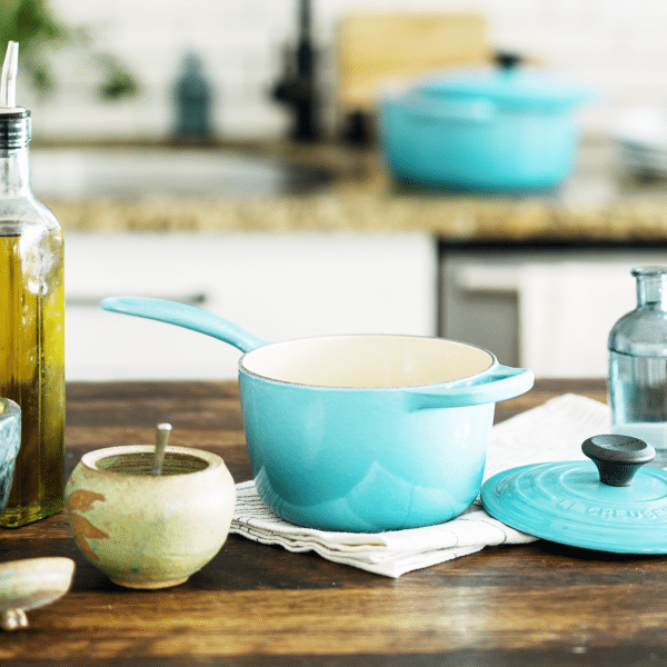 Kitchen counter with a mortar & pestle, blue ceramic pots and pans and various cooking oils