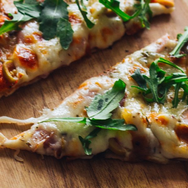 Close up of pizza slices with arugula sprinkled on top