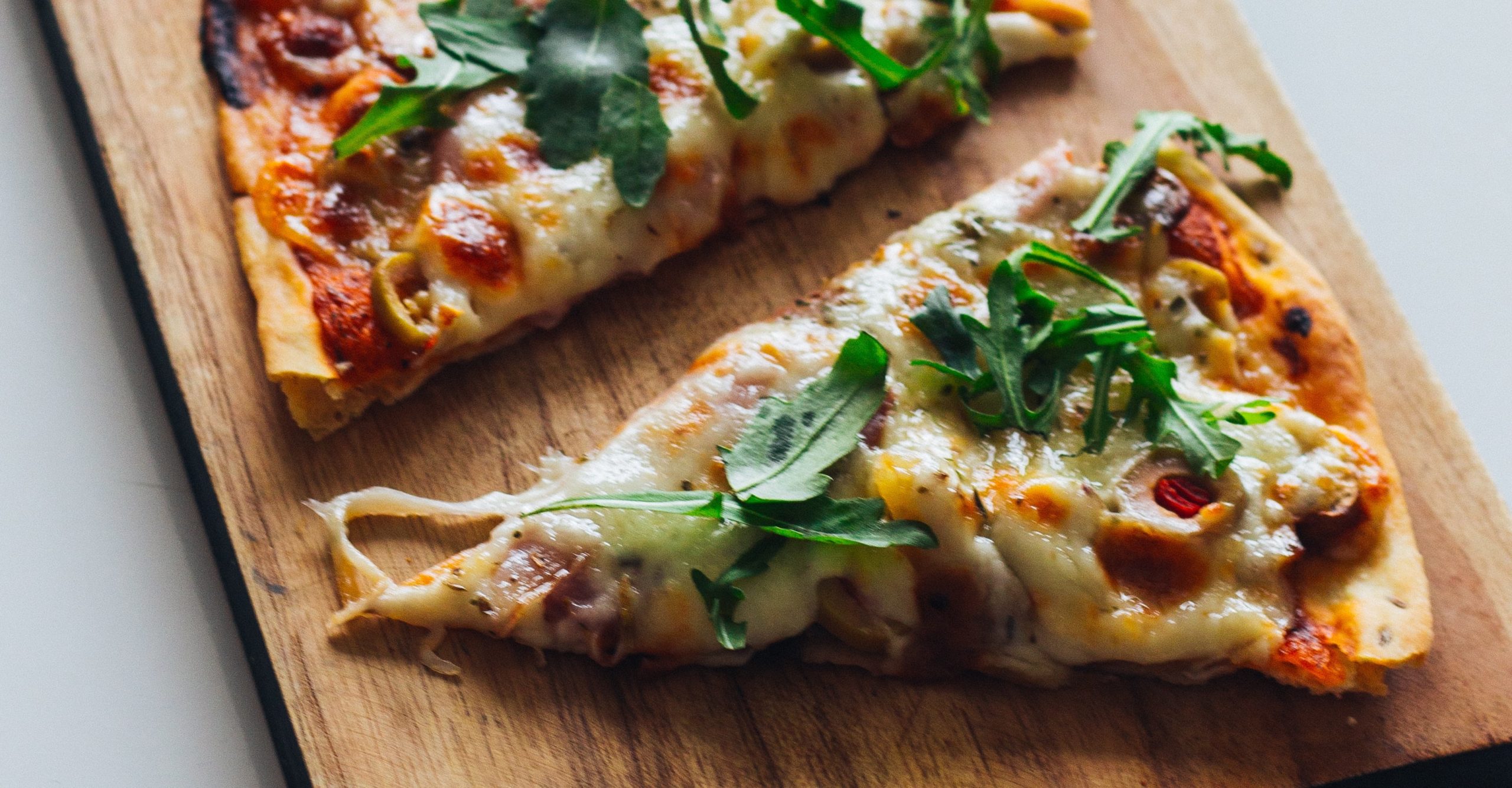 Close up of pizza slices with arugula sprinkled on top