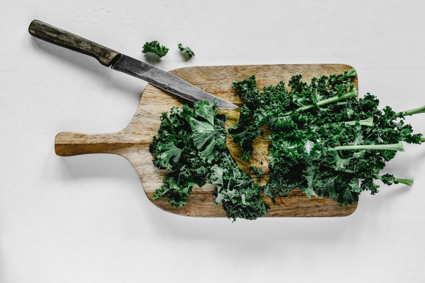 Kale on a cutting board with a knife