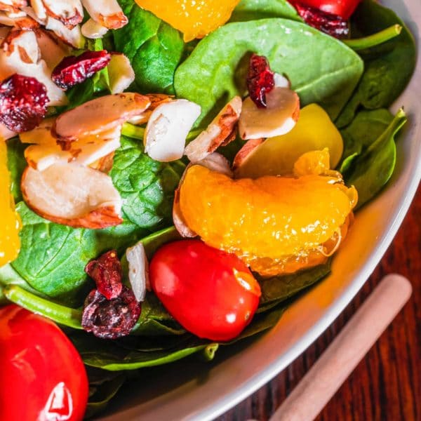 spinach salad with mandarins, dried cranberries, and other toppings