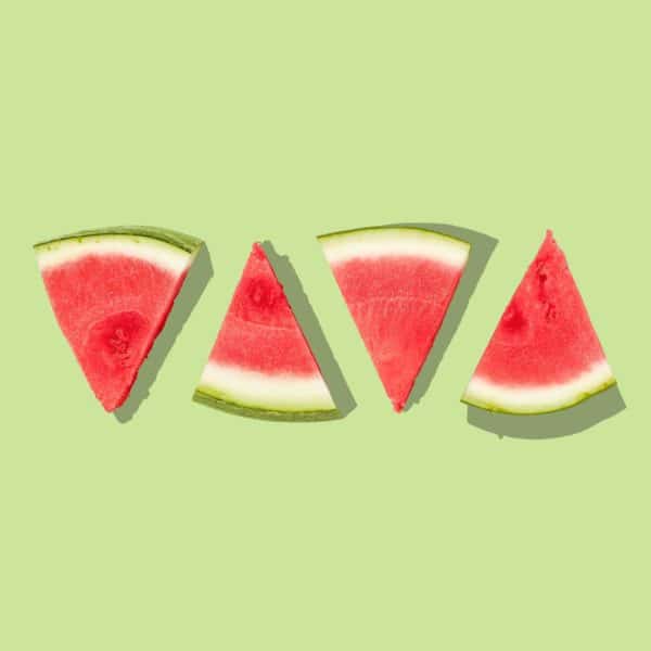 triangular pieces of cut watermelon on a green background