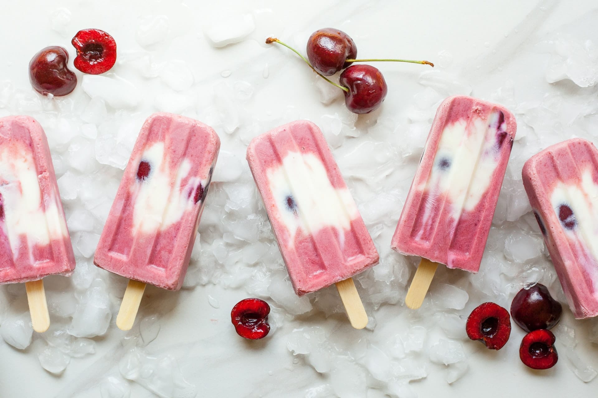 pink and white popsicles with cherries