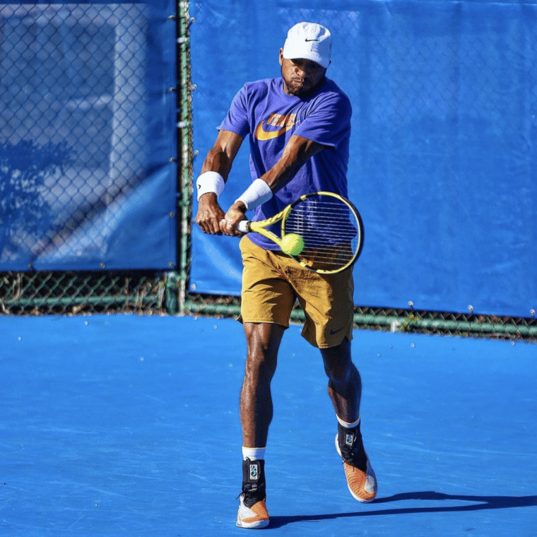 Professional tennis player Nicholas Monroe hitting the tennis ball with his racket