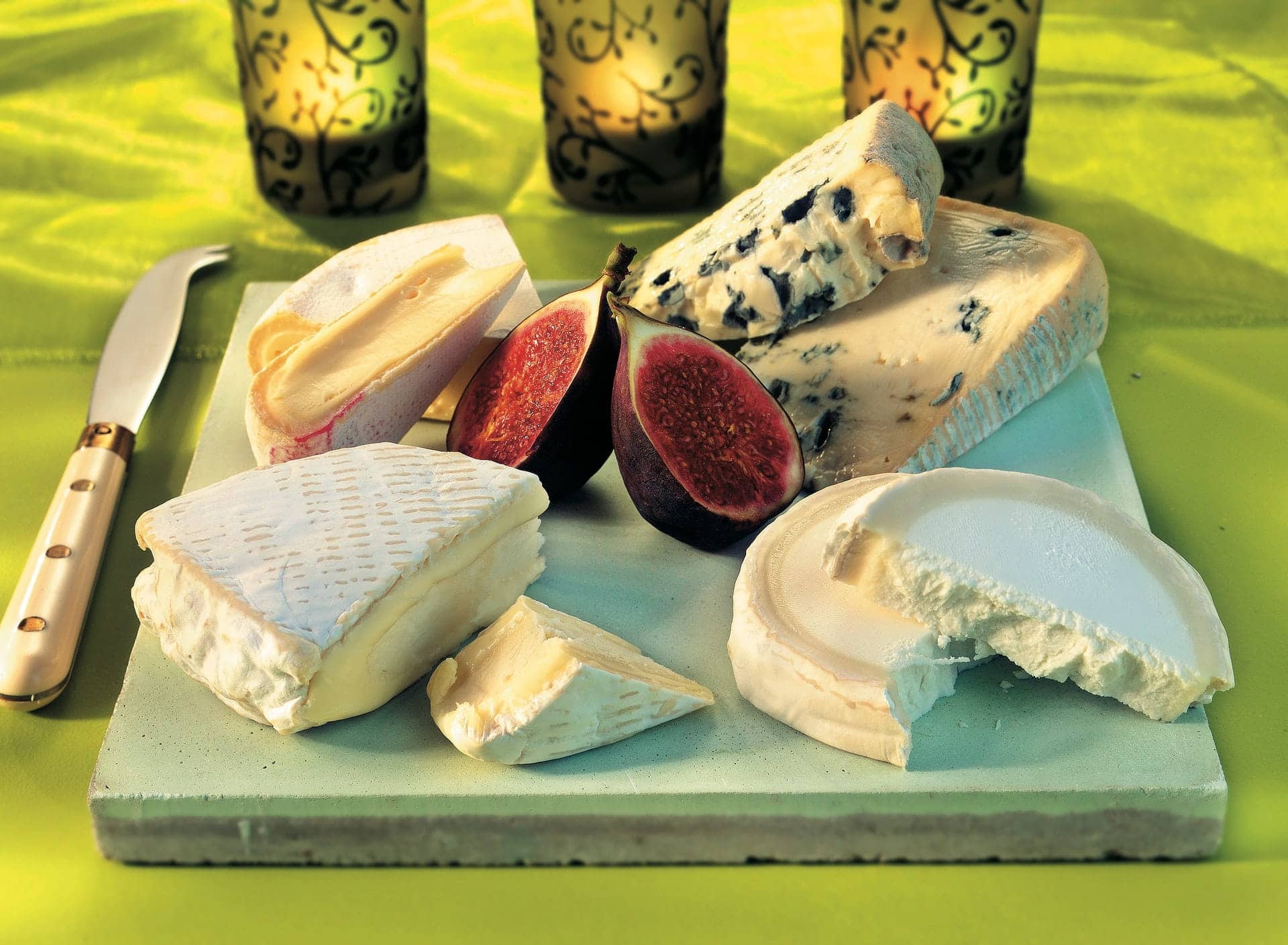 different types of cheese with figs on a cutting board