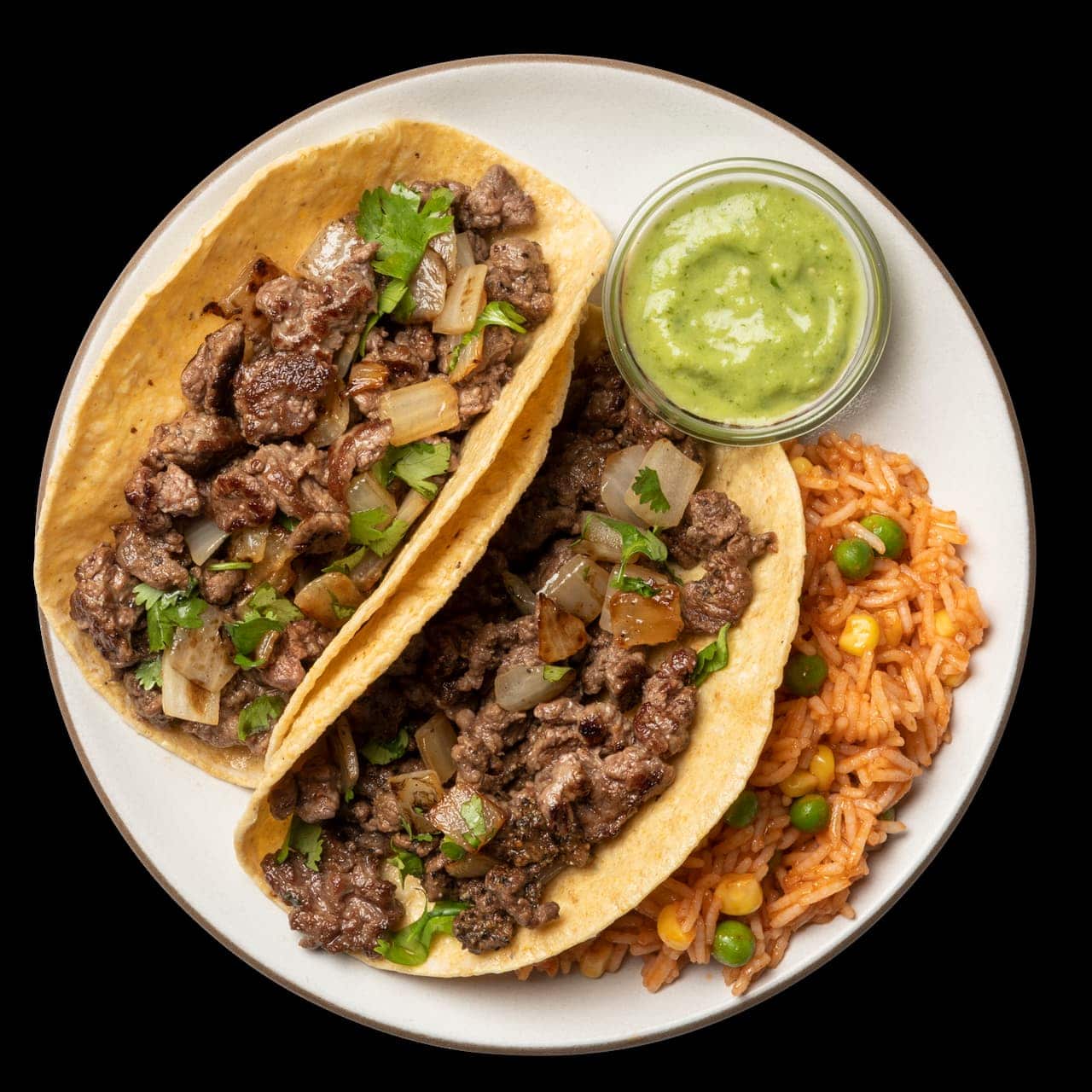 steak tacos with guacamole and rice pilaf on a white plate